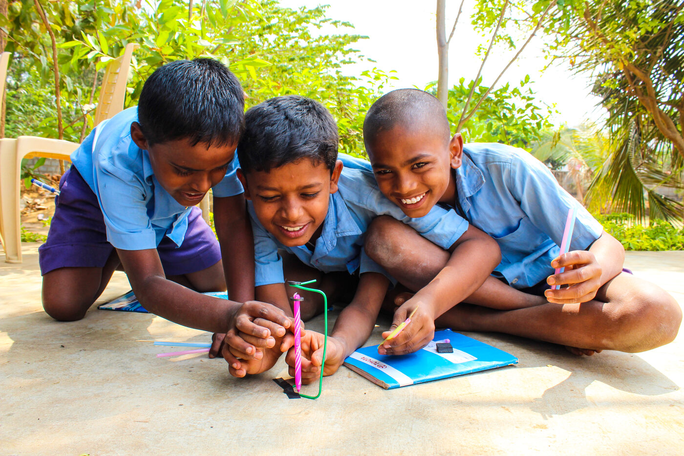 Children sitting on the floor building models from colourful hands-on materials.