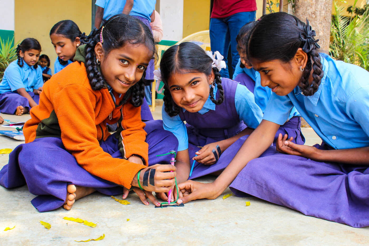 Students in uniform at a table working together on a colourful hands-on classroom activity.